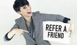 A woman holding a sign that says " refer friends ".