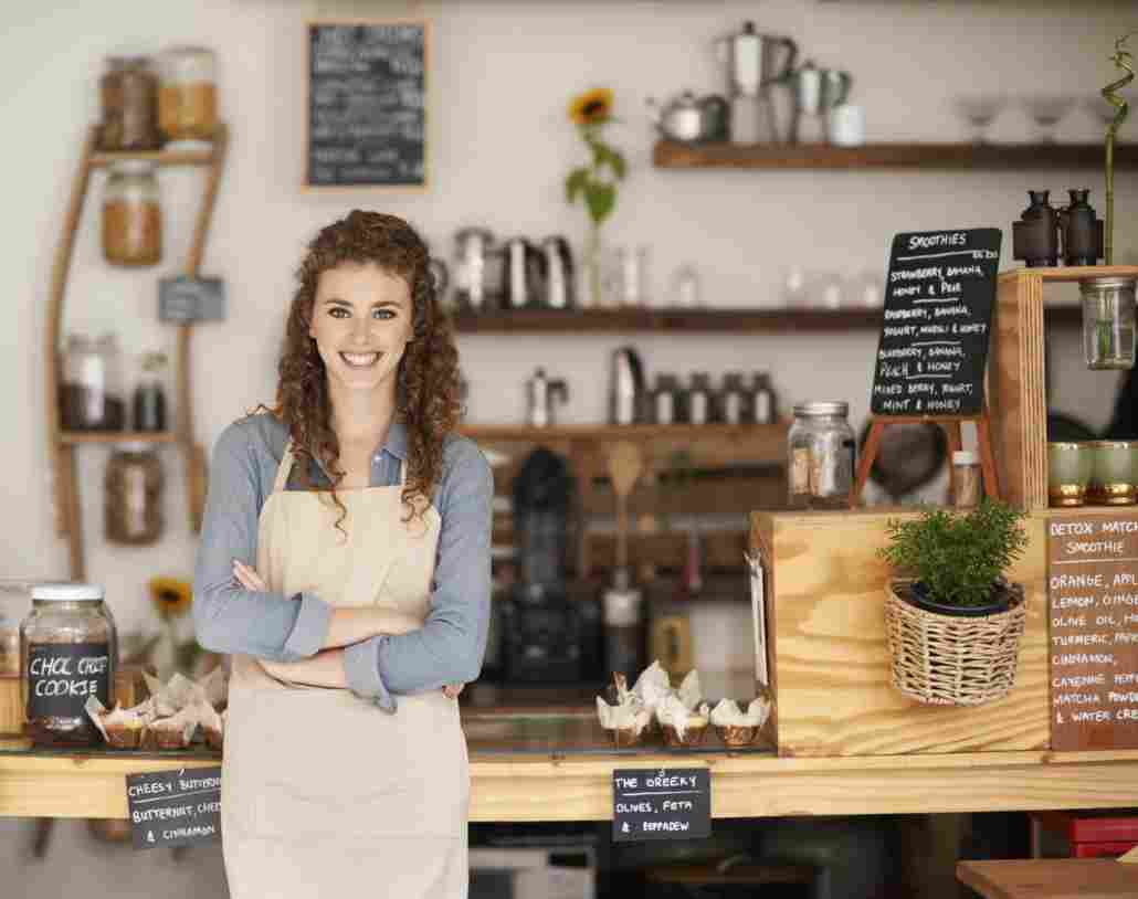 A woman standing in front of shelves with jars.